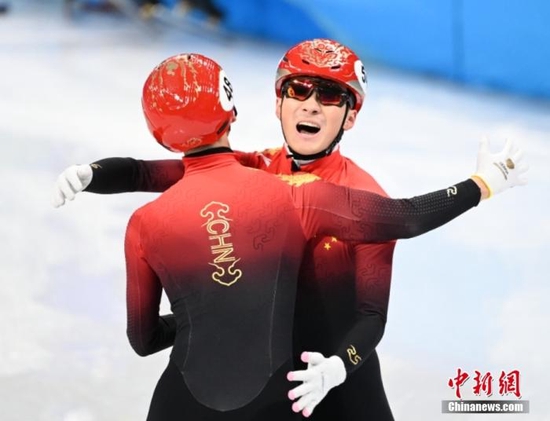 在2月5日晚结束的短道速滑混合团体接力决赛中，由武大靖、任子威、范可新、曲春雨组成的中国队率先冲过终点，为中国体育代表团拿到本届冬奥会首枚金牌。图为武大靖（左）和任子威在比赛后庆祝。&nbsp;中新社记者 毛建军 摄