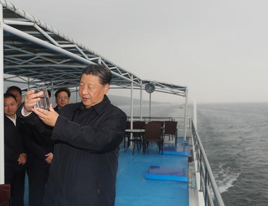  ↑5月13日下午，习近平在南阳市淅川县乘船考察丹江口水库时，察看现场取水水样。