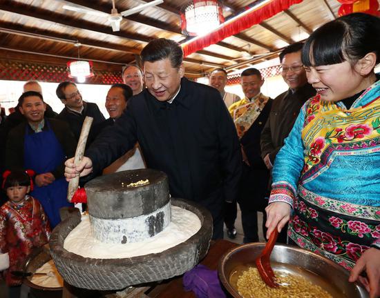 △ 　　2018年2月12日，习近平在阿坝藏族羌族自治州汶川县映秀镇考察时同居民群众一起磨豆花。