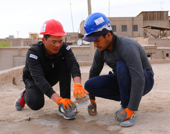  在乌兹别克斯坦希瓦古城哈桑·穆拉德库什别吉清真寺，中方文物修复人员指导乌方工作人员修复清真寺屋顶。