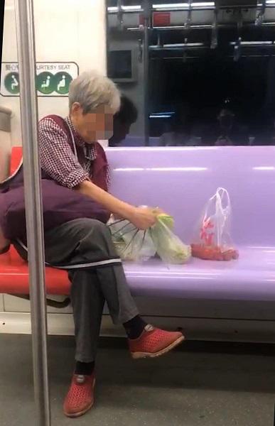  图说：老人坐在车厢内悠然熟练地拣菜  来源/潘金鳌 摄