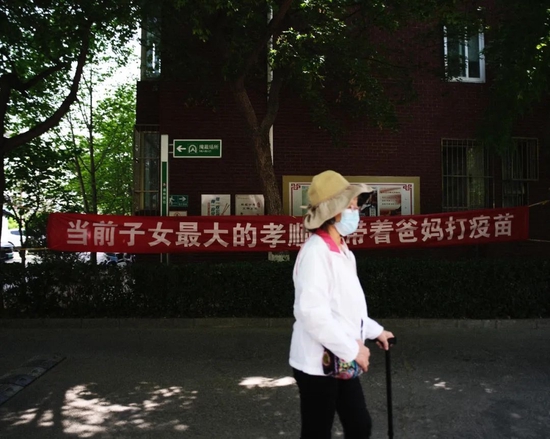 4月23日，北京，某小区内悬挂“当前子女最大的孝顺是带着爸妈打疫苗”的横幅。