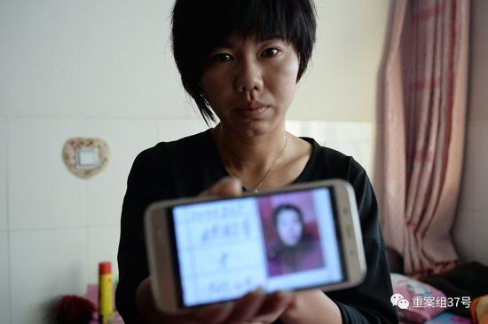 2016年12月14日下午，王秀芬手捧着手机里母亲的照片，这是灾难过后还能找到的为数不多的父亲母亲的照片。