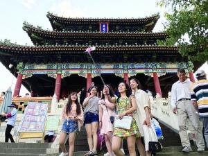  不少游客身着夏装在景山公园留下美丽的身影。 北京晨报记者 王巍/摄