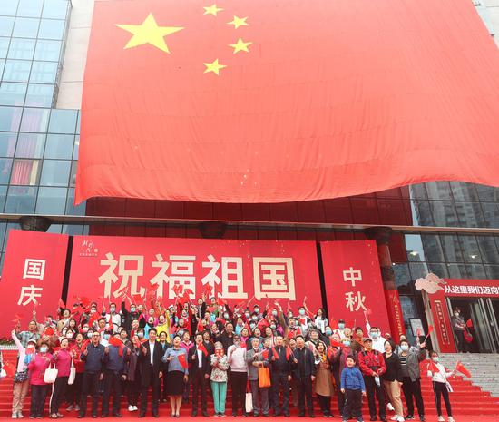 在北京市朝阳区文化馆举办的国庆专题活动上，嘉宾与国旗合影（10月1日摄）。新华社记者 金良快 摄
