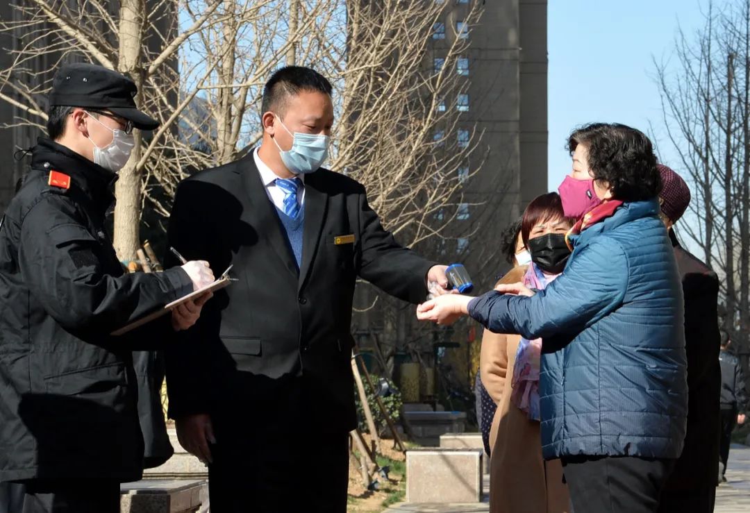 3月17日，一社区门口，工作人员对进入户外便民超市购物的居民进行登记和测体温 董永博/摄