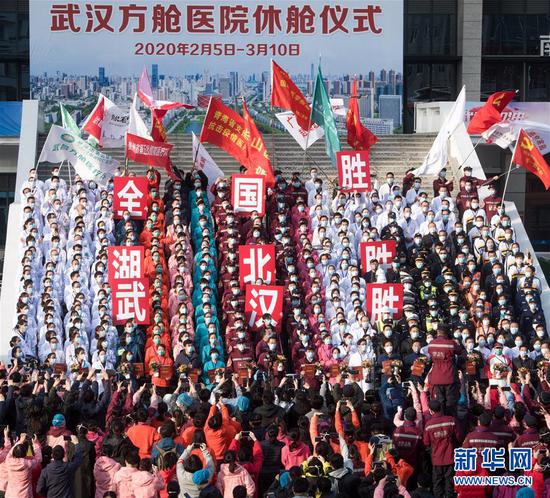 　　3月10日，武汉所有方舱医院全部休舱，医护人员在武昌方舱医院前庆祝。 新华社记者 肖艺九 摄