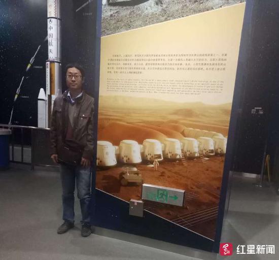 今年1月带儿子去北京国家天文台时，李大鹏在“火星一号”的介绍资料前留影。图片来源：受访者供图