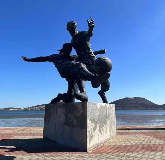 辽宁省军事体育航海运动学校旁边的滨海公园里，有一座足球雕塑。
