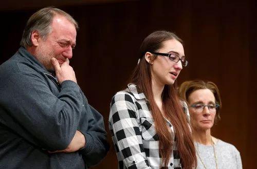 2018年2月2日,在美国密歇根州夏洛特市,受害者凯蒂·布莱克(中)在父亲和教练的陪同下出席听证会。新华社/路透