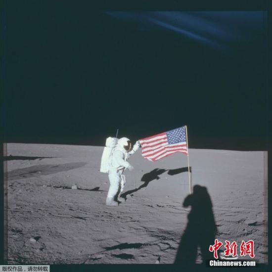 资料图：1969年11月16日，阿波罗12号宇航员查尔斯·“皮特”·康拉德二世站在月球插着的美国国旗旁边。