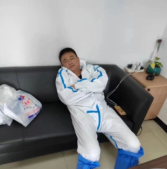 陈联义在小区组织了一天核酸检测工作后，坐在沙发上睡着了。（受访者供图）