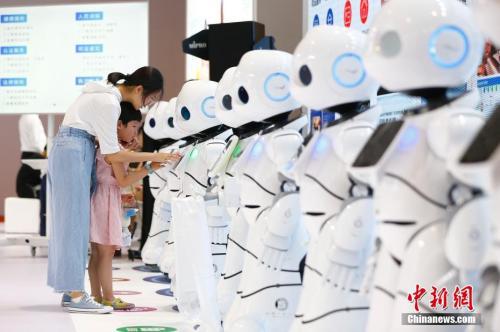 图为小朋友与机器人互动。 中新社记者 富田 摄