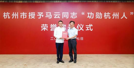 浙江省委常委、杭州市委书记周江勇(右)为马云授证书和印章
