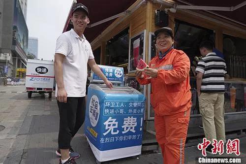 资料图：北京街头，环卫工人从“爱心冰箱”中取用西瓜。 中新社记者 贾天勇 摄