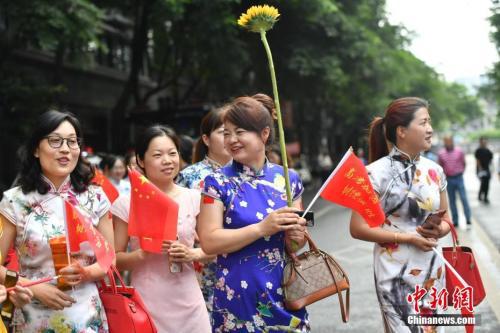  6月7日，成都树德中学考点外，一些学生家长穿上旗袍手持向日葵为孩子加油助阵，寓意“旗开得胜”和“一举夺魁”。张浪 摄