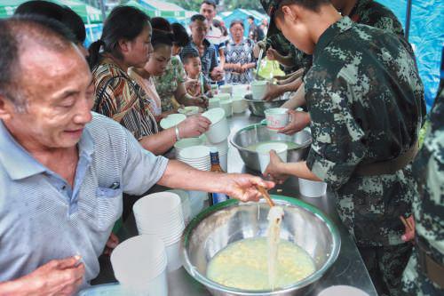  ▲昨晚，双河镇受灾村民吃上了第一顿热饭，武警部队提供的鸡蛋面。