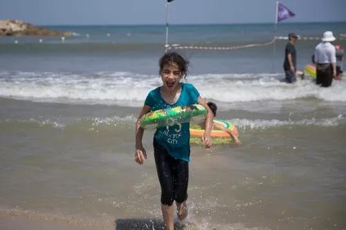 7月8日，在以色列特拉维夫，来自约旦河西岸巴勒斯坦城市希伯伦的13岁女孩巴娅第一次亲眼看到大海。新华社记者郭昱摄
