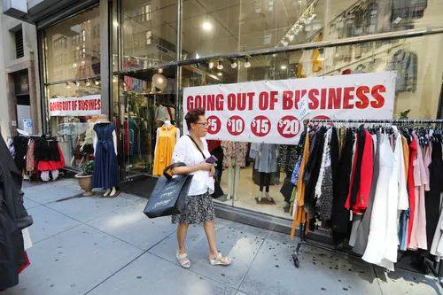 9月4日，在美国纽约，一名女子查看一家店铺促销的服装。新华社记者 王迎 摄