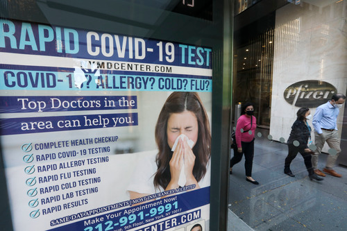 11月9日，在美国纽约，人们从一处快速检测新冠病毒的广告旁走过。新华社记者王迎摄