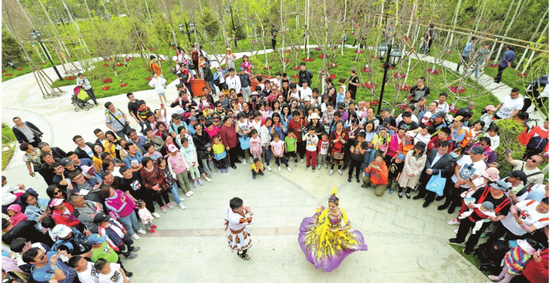 5月3日，北京世园会新疆室外展园绿树环绕的后园里，精彩的歌舞表演吸引众多游客。