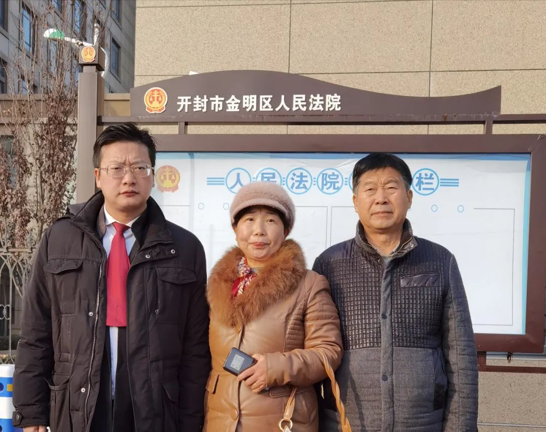 姚策的生父生母（右一、右二）及姚策的代理律师周兆成（左一）在法院外合影。受访者供图