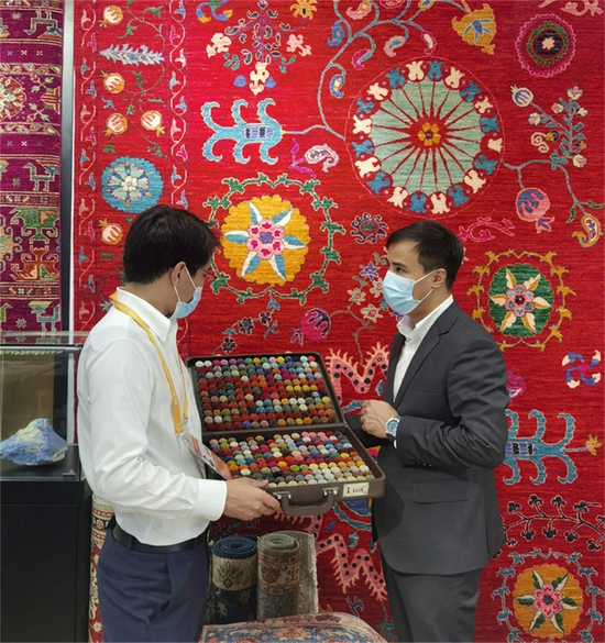 11月5日，阿富汗参展商阿里·法伊兹（右）在第四届进博会阿富汗手工羊毛地毯展台忙碌。新华社记者 吴宇 摄