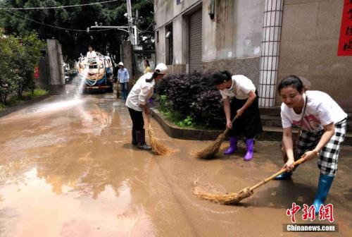 资料图：5月17日，福建省防汛办通报称，受强降雨影响，三明市、龙岩市、漳州市、南平市等地及时转移危险区域民众5153人次。图为龙岩市连城县粟园社区民众正展开灾后清扫。中新社发 黄水林 摄