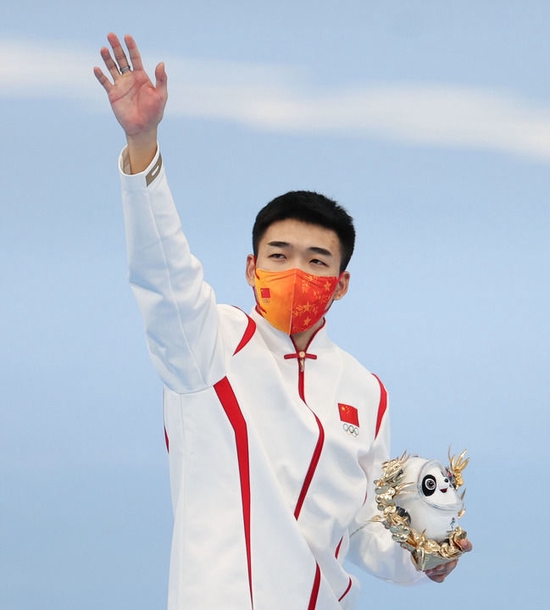  2月12日，中国选手高亭宇手持“金墩墩”向观众致意。新华社记者 丁旭 摄
