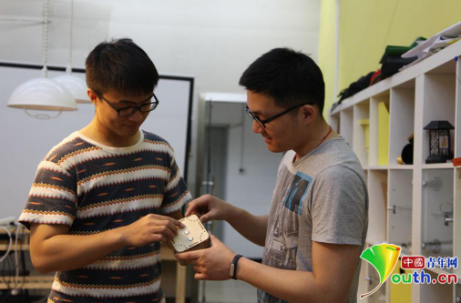 清华大学创客空间协会成员张承巍(左)与毕滢(右)正在引见他们的创意成果“音乐盒子”。材料图