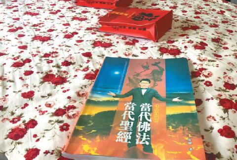 3月15日，陷入“五行币”传销的周英（化名）向记者出示了关于传销头目张健的书籍。    新京报记者 刘经宇 摄