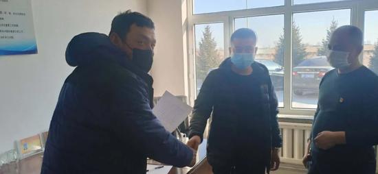 张旭(左)从青山村村委会拿到了转场通畅证。