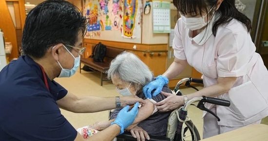 5月25日上昼，东京齐江户川区的老年东谈主次序入住者正在接种新冠疫苗第四剂  图：共同社