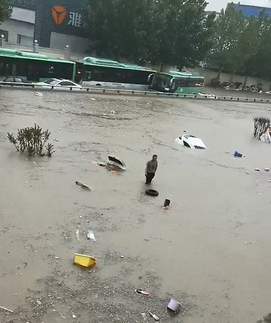 王文学站在车顶上等待救援（网络视频截图）。