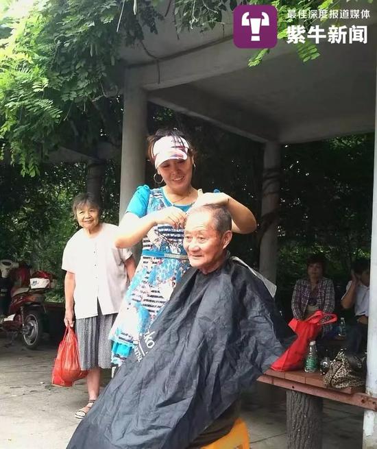  热心公益的周大姐在给老人理发