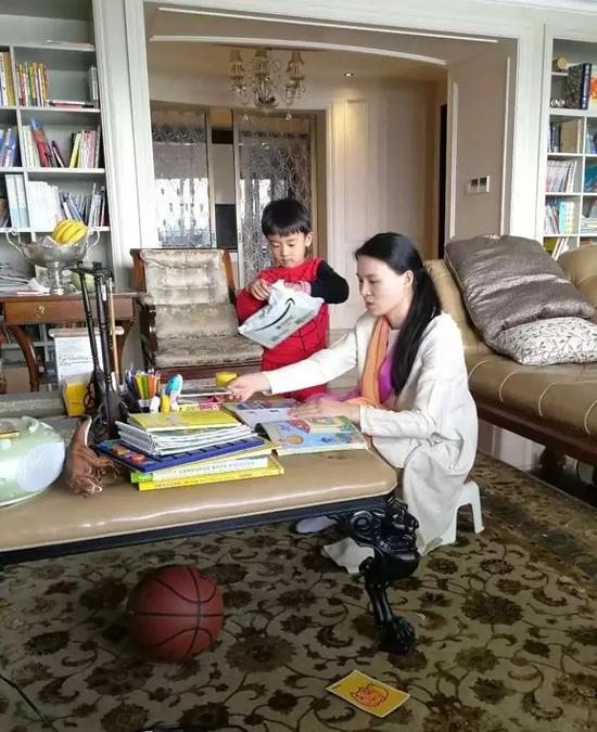 朱小贞和小儿子在客厅里,背后书架为起火点.