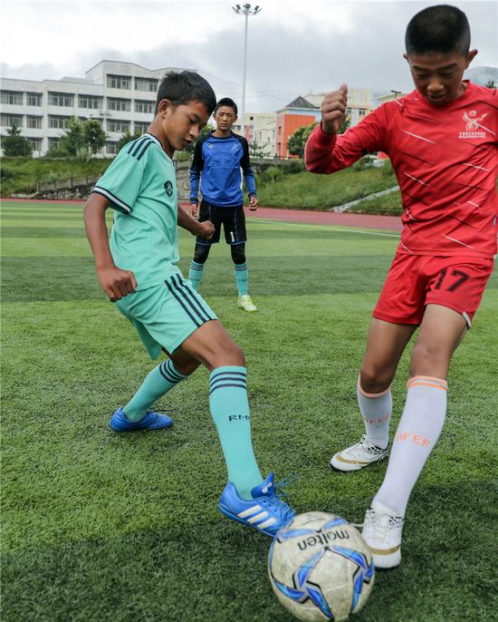 在四川省昭觉县拉莫足球场，阿作伍勒（左）在训练中拼抢（8月13日摄）。新华社记者沈伯韩摄