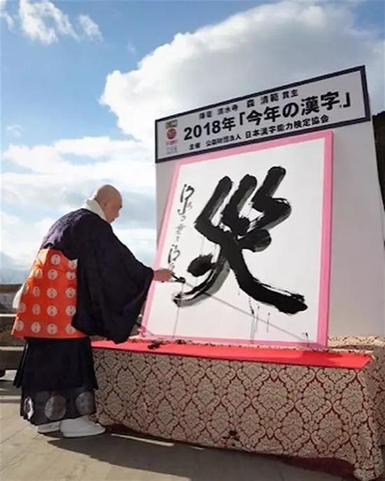 (图为净水寺的森清范方丈挥笔写下“灾”字)