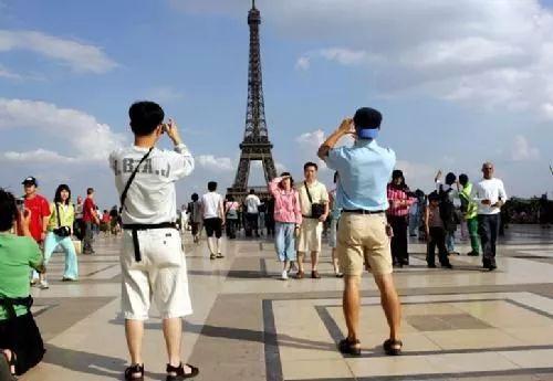 ▲中国游客在法国埃菲尔铁塔前拍照