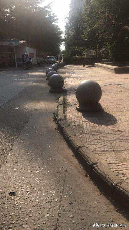 为了防止停放车辆,绿化带旁有许多石墩