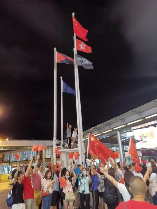 5日晚，天星码头海港城前，五星红旗被爱国爱港人士重新升起。 杨升 摄