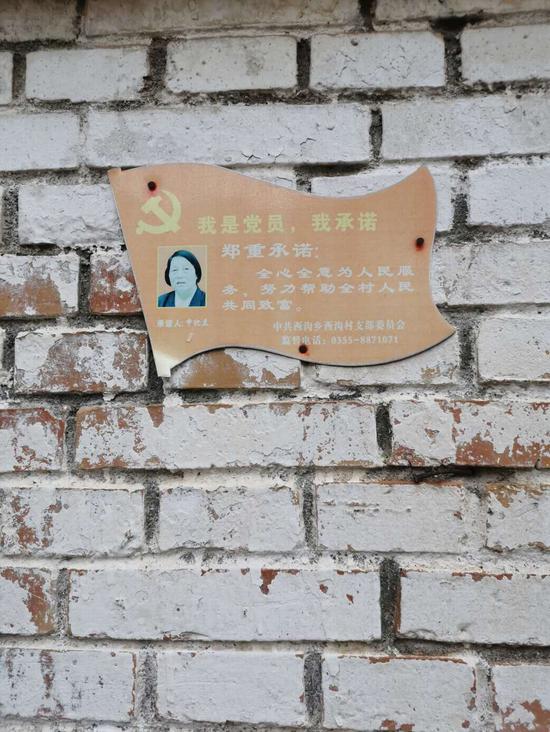 申纪兰家门口贴着"党员承诺牌".