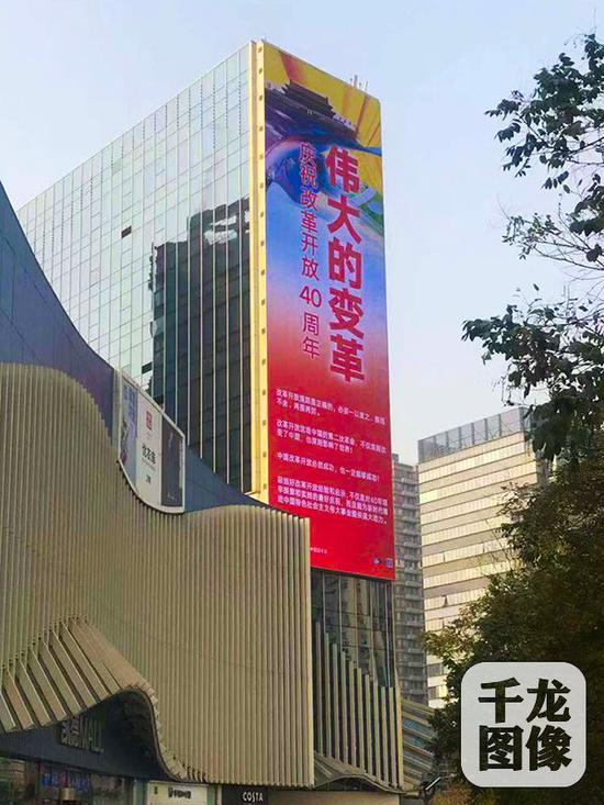 12月2日，“伟大的变革——庆祝改革开放40周年”宣传挂图亮相北京街头，为庆祝改革开放40周年营造热烈氛围。图为凯德茂附近的户外大屏。 千龙网发