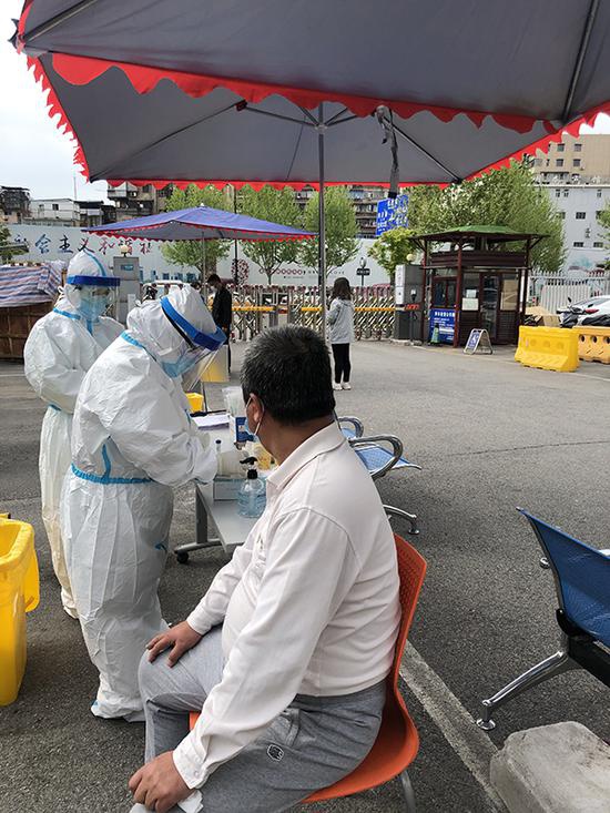 体检中心在空旷的位置为团体进行核酸检测,拍摄于4月12日.