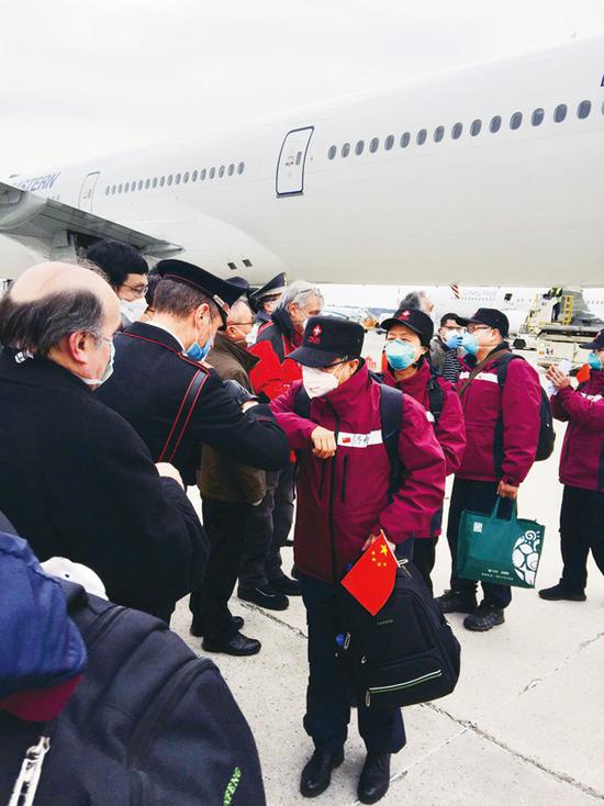 2020年3月25日，在意大利米兰马尔奔萨机场，意方人员以“击肘”的方式欢迎中国第三批赴意大利抗疫医疗专家组成员的到来。中国第三批赴意大利抗疫医疗专家组一行14人25日抵达米兰马尔奔萨机场。专家组由国家卫生健康委员会组建，成员由福建省卫健委选派，并随所乘飞机携带了呼吸机、监护仪、口罩等中方捐助的医疗物资。 新华社发