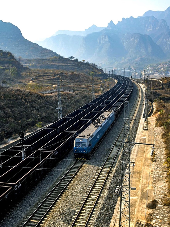 △一列满载煤炭的列车通过中南铁路长治平顺县段。中南铁路西起山西吕梁，东至山东日照港。（图/视觉中国）