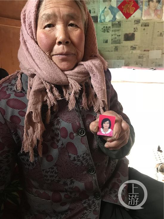 ▲芳芳的婆婆，手里拿着孙女芳芳的照片。摄影/上游新闻记者 范永松