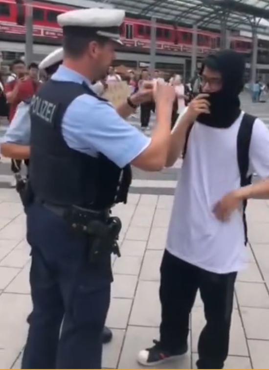  17日，在德国科隆，警察要求蒙面人摘掉面罩