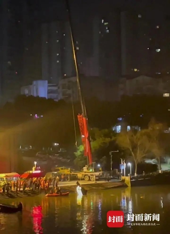  9日晚，救援人员在现场打捞坠河车辆。视频截图