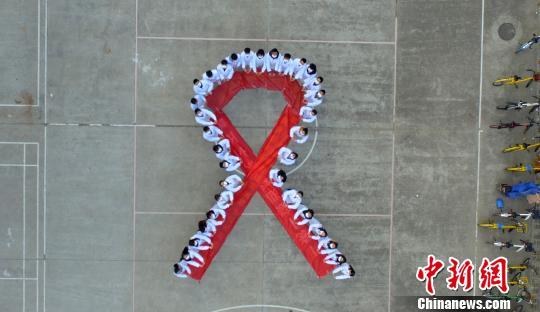 资料图：大学生们携手“抗艾”，拼大型“红丝带”图案。　孟德龙 摄
